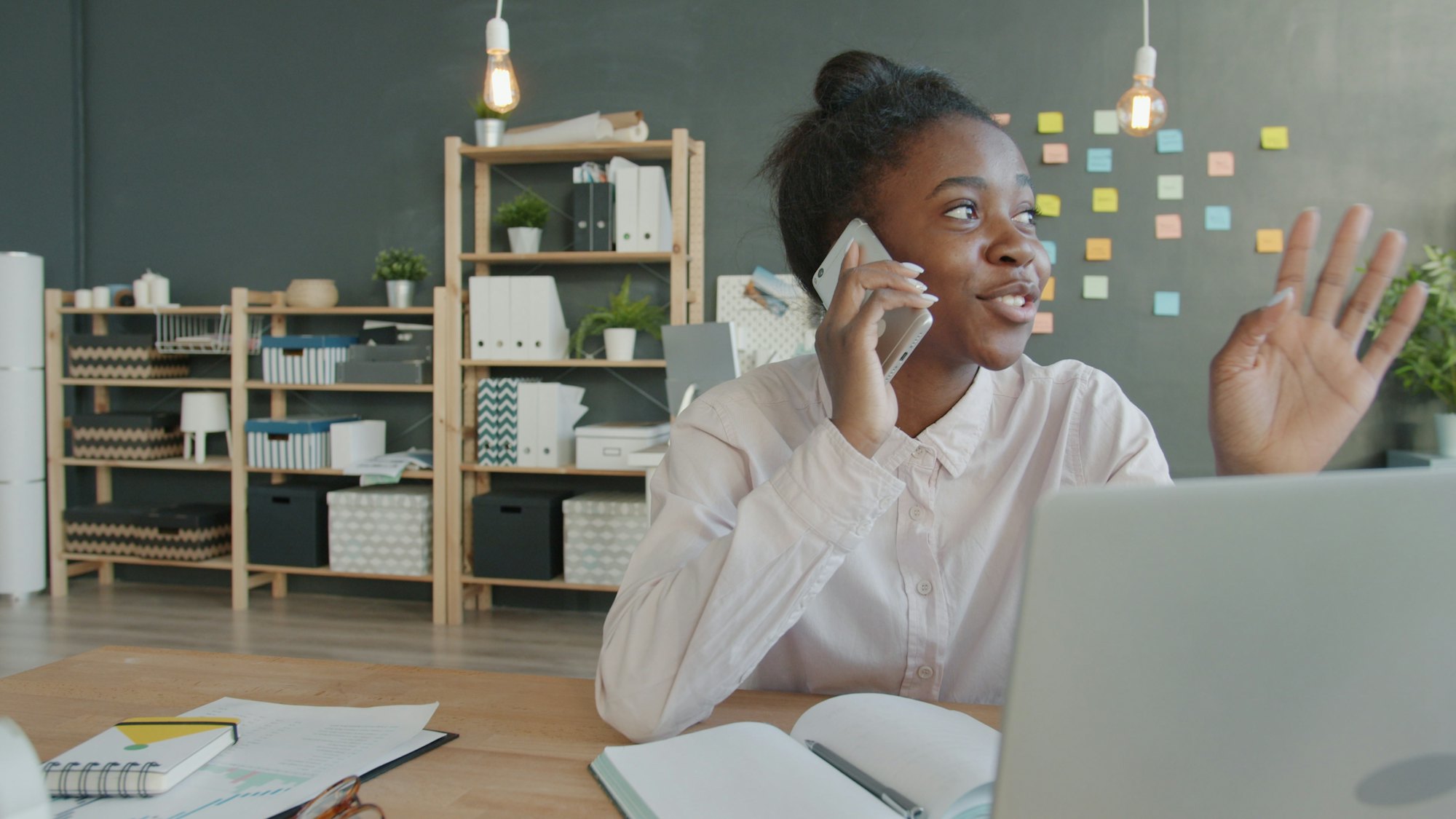 A travel agent on the phone with a client, at her desk.